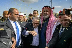 This handout picture released by the Lebanese Government Press Office shows Lebanon's Prime Minister Nawaf Salam being showered with confetti as he is received by locals during a tour in the heavily-damaged southern village of Dhayra near the border with Israel on February 7, 2026. (Lebanese Government Press Office / AFP) 