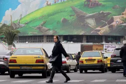 إيرانية تمر أمام لوحة دعائية معادية للولايات المتحدة معروضة في ميدان ولي عصر وسط طهران (أ.ف.ب)
