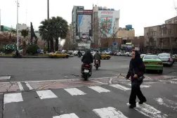 Iranians cross a road near an anti-US and anti-Israeli billboard reading "You start... we finish it" in Palestine Square in Tehran, Iran, 09 February 2026, amid heightened regional tensions. (EPA)