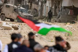 فلسطينيون يتظاهرون أمام جنود إسرائيليين أغلقوا مدخل مخيم نور شمس في الضفة الغربية (أ.ف.ب)