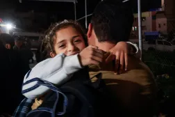 فلسطيني يحمل طفلة بينما يصل الفلسطينيون القادمون من معبر رفح الحدودي إلى مستشفى ناصر في خان يونس جنوب قطاع غزة يوم 9 فبراير الحالي (رويترز)