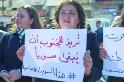 سوريون يرفعون لافتات في «ساحة الكرامة» المركزية بمدينة السويداء في جنوب سوريا 25 فبراير 2025 (أ.ف.ب)