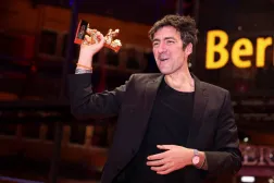 المخرج الألماني إيلكر كاتاك يرفع جائزة الدب الذهبي لأفضل فيلم في مهرجان برلين السينمائي (رويترز) 