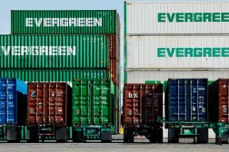 حاويات شحن مكدسة بينما تستقر أخرى على هياكل شاحنات نقل في ميناء لوس أنجليس (أ.ف.ب)