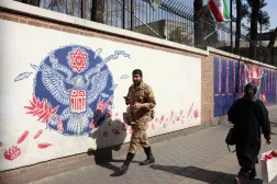 جندي إيراني يمر بجوار جدارية مناهضة للولايات المتحدة في طهران (إ.ب.ا) 