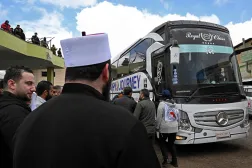 حافلة تقل سجناء خلال مراسم تبادل أسرى بين السلطات السورية ومقاتلين دروز في السويداء 26 فبراير (أ.ف.ب)