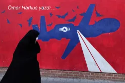 Tahran'daki eski ABD büyükelçiliğindeki bir duvar resminin önünde İranlı kadın, 1 Şubat (AFP)