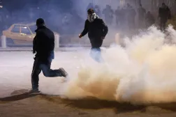 متظاهرون وسط الغاز المسيل للدموع بينما يحاول أنصار جماعات مسلحة عراقية التقدم نحو السفارة الأميركية الواقعة بـ«المنطقة الخضراء» في بغداد (رويترز)