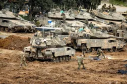 Israeli soldiers work on the belts for their tanks at a staging area in the Upper Galilee in northern Israel near the border with Lebanon on March 13, 2026. (AFP) 