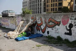 أطفال نازحون يجلسون على جانب الطريق في العاصمة بيروت (رويترز)