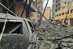 Debris is strewn along a street and vehicles after a residential apartment block was struck in an Israeli airstrike in Beirut's southern suburb of Haret Hreik on March 15, 2026. (AFP)