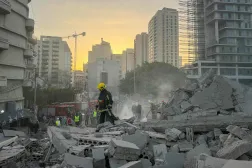 A firefighter walks past rubble at the site of an Israeli airstrike in Beirut's Bashoura neighborhood on March 18, 2026. (Photo by Ibrahim AMRO / AFP)