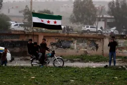 Demonstrators carry a Syrian flag during a rally commemorating the15th anniversary of the Syrian uprising against the Bashar Assad regime in Daraa, southern Syria, Wednesday, March 18, 2026. (AP Photo/Omar Sanadiki)