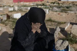 فلسطينية تبكي لدى زيارة قبور أقاربها في خان يونس جنوب قطاع غزة... الجمعة (إ.ب.أ)