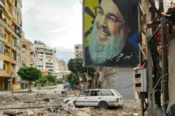 Beyrut'un güney banliyösünde enkazın arasında çekilmiş eski Hizbullah Genel Sekreteri Hasan Nasrallah'ın posteri (AFP)