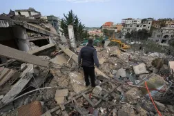  A man stands as rescuers work at the site of Israeli strike, amid escalating hostilities between Israel and Hezbollah, as the US-Israeli conflict with Iran continues, in Kfar Hatta in southern Lebanon, April 5, 2026. (Reuters)