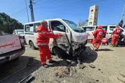 Lebanese Red Cross volunteers inspect the damage to their rescue vehicles at the site of an Israeli drone strike that targeted their headquarters in the southern city of Tyre on April 13, 2026. (Photo by Kawnat HAJU / AFP)