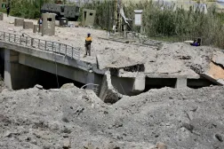 16 Nisan 2026'da Lübnan'ın güneyindeki Sur kenti yakınlarında İsrail'in hava saldırısına hedef olan Kasımiye Köprüsü'nün hasar görmüş bir bölümünde duran bir adam (EPA)