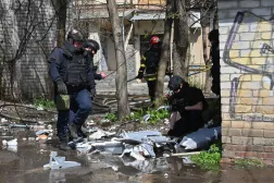 Ukrainian law enforcement officers inspect fragments of a drone at the site of an air attack in Kharkiv on April 16, 2026, amid the Russian invasion of Ukraine. (Photo by SERGEY BOBOK / AFP)