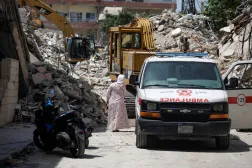 A woman walks next to an ambulance at the site of an Israeli strike carried out before a 10-day ceasefire between Lebanon and Israel went into effect, in Tyre, Lebanon, April 17, 2026. (Reuters)