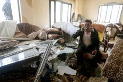 مواطن يشرب الشاي في بيته المتضرر في بلدة قانا في جنوب لبنان (أ.ف.ب)