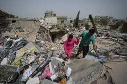 Residents walk on the rubble of destroyed houses on the second day of a ceasefire between Hezbollah and Israel in Jibchit village, south Lebanon, Saturday, April 18, 2026.(AP Photo/Mohammed Zaatari)