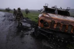 In this handout photograph taken on April 24, 2026 and released on April 25, 2026 by the press service of the 93rd Kholodnyi Yar Separate Mechanized Brigade of the Ukrainian Ground Forces, Ukrainian servicemen walk on a road past a destroyed military vehicle, near Druzhkivka, in Donetsk region, amid the Russian invasion of Ukraine. (Photo by IRYNA RYBAKOVA / The 93rd Kholodnyi Yar Separate / AFP) 