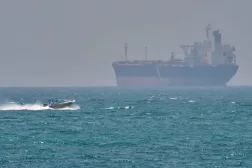 A boat sails past a tanker anchored on the Strait of Hormuz off the coast Qeshm island, Iran, April 18, 2026. (AP)