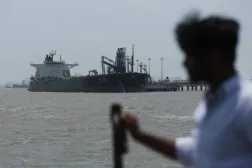 Dün Hürmüz Boğazı'nı geçtikten sonra Mumbai'de petrol yükünü boşaltan "Desh Garima" tankerine bakan bir adam (Reuters)