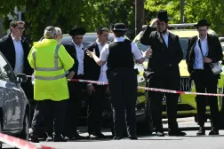Local residents look on from outside a cordoned off area in the Golders Green neighbourhood of north London on April 29, 2026, following the stabbing to two people nearby. (Photo by JUSTIN TALLIS / AFP)