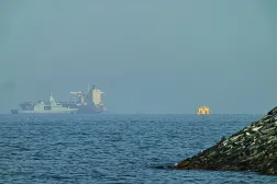  An Emirati patrol boat, left, is near a tanker anchored in the Gulf of Oman near the Strait of Hormuz, as seen from a coastal road near Khor Fakkan, United Arab Emirates, Friday, May 1, 2026. (AP) 