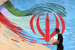 An Iranian man walks past an anti-US and anti-Israel mural painted on a wall, in the capital Tehran on May 10, 2026. (AFP)