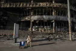 A boy plays the accordion in front of a shopping center damaged by Russian strikes in Kyiv on May 25, 2026, amid the Russian invasion of Ukraine. (AFP) 