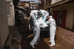 Uganda Kızılhaç Derneği çalışanları, Kampala'da Ebola şüphesi bulunan bir kişinin cesedini taşıyor (AFP)