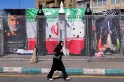 A woman walks past Iranian missile models in Tehran’s Valiasr Square on April 6, 2026. (AFP) 