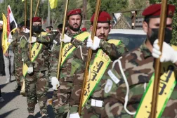 Fighters carry flags of Iraq and paramilitary groups, including Kataib Hezbollah, during a funeral in Baghdad for five militants killed in a US strike in northern Iraq, on Dec. 4, 2023. (AFP via Getty Images) 