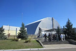 15 September 2021, Ukraine, Chornobyl: A group of tourists stand at the memorial in front of unit four of the Chornobyl nuclear power plant in Ukraine, which exploded in 1986. (dpa) 