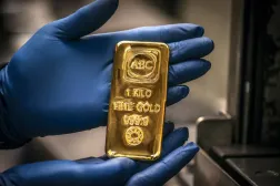 Bir işçi Sidney'deki rafineride bir kilogramlık altın külçesini gösteriyor (AFP)