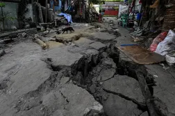  People sit outside their house on an earthquake-cracked street a day after the magnitude 7.8 quake in General Santos, southern Philippines, June 9, 2026. (Reuters)