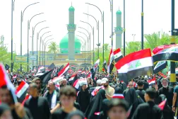 أنصار مقتدى الصدر يلوّحون بالعلم العراقي خلال مظاهرة دعماً لإجراءات مكافحة الفساد في النجف (أ.ب)