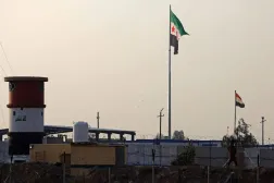 Syria's (L) and Iraq's national flags are pictured near the Iraqi-Syrian border, in Al-Qaim, western Iraq on January 23, 2026. (AFP)