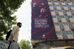 Tahran’da bir binaya asılan devasa propaganda afişinde, ABD Başkanı Donald Trump ile İsrail Başbakanı Binyamin Netanyahu’nun resimleri yer alıyor ve afişin üzerinde “İran halkının intikam denizinde boğulacaksın” yazıyor. (EPA)