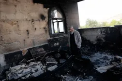 (foto altı) Nablus yakınlarında yerleşimciler tarafından ateşe verilen camideki hasarı inceleyen bir Filistinli (Reuters)