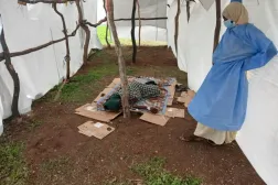 Kolera hastası bir kişi, şaşkın bir sağlık görevlisinin yanında duruyor (Mülteci Koordinasyon Birimi)