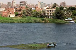 A fisherman travels on a boat with his family during low water levels on the River Nile with crowded residential buildings in the capital city of Cairo, Egypt, August 3, 2026. REUTERS/Amr Abdallah Dalsh