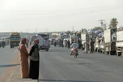 Onlookers stand along the road as Syrian Kurds, who were living in displacement camps in the city of Hasakeh, prepare to head back to the northeastern border town of Ras al-Ain on August 10, 2026. (AFP)