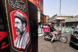A delivery person rides a motorcycle near an image of Iran's Supreme Leader Mojtaba Khamenei at Valiasr Square in central Tehran on August 8, 2026. (AFP)