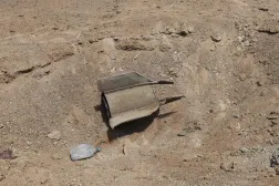 The remains of a military projectile are embedded in the ground in the Port of Mokha the day after an attack by the Houthis on the city of Mokha, held by Yemen's legitimate Aden-based government on August 10, 2026. (AFP)