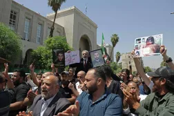 سوريون يحملون صور أقاربهم الذين قتلوا خلال حرب نظام الأسد عليهم يحتفلون الثلاثاء أمام القصر العدلي بأحكام الإعدام على بشار وشقيقه ماهر وبقية رموز الحكم (أ.ف.ب)