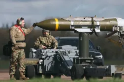 ABD askeri personeli, RAF Fairford'da bir B-1 Lancer bombardıman uçağından mühimmatı çıkarıyor (Arşiv- AFP)